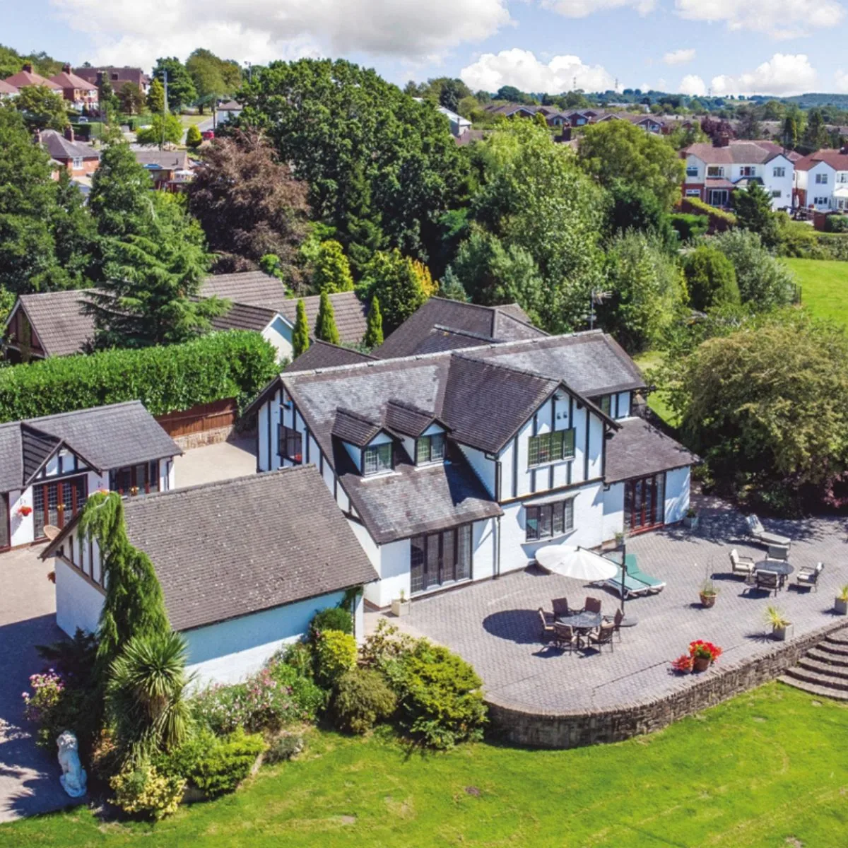 Little Ash Farm house and patio surrounded by trees and gardens